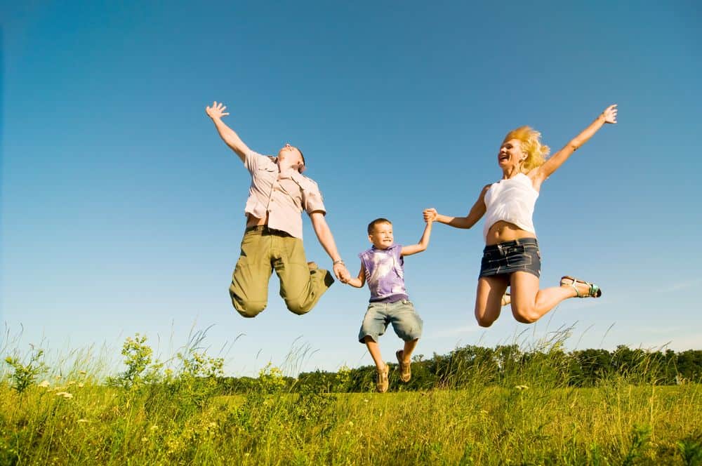 family jumping in a field
