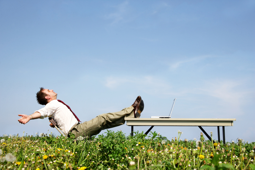 business man kicking feet up in field