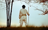 man in white standing in field