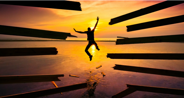 silhouette of person jumping through wood