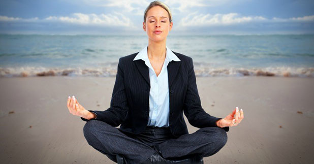 business woman meditating on beach