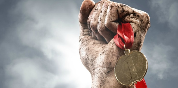 dirty hand holding a medal