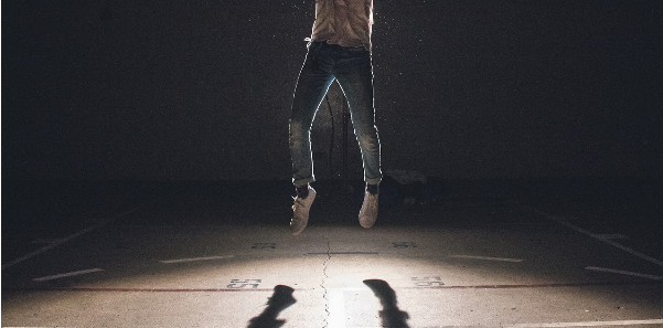 person jumping dark lighting